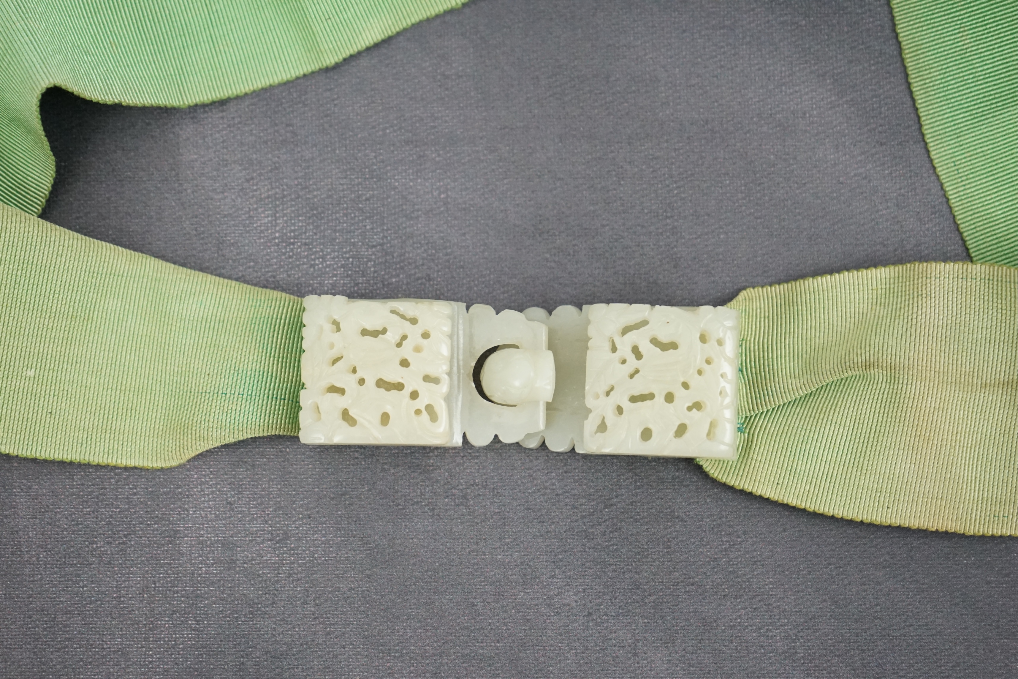 A Chinese pale celadon jade two-piece reticulated belt buckle, 19th century